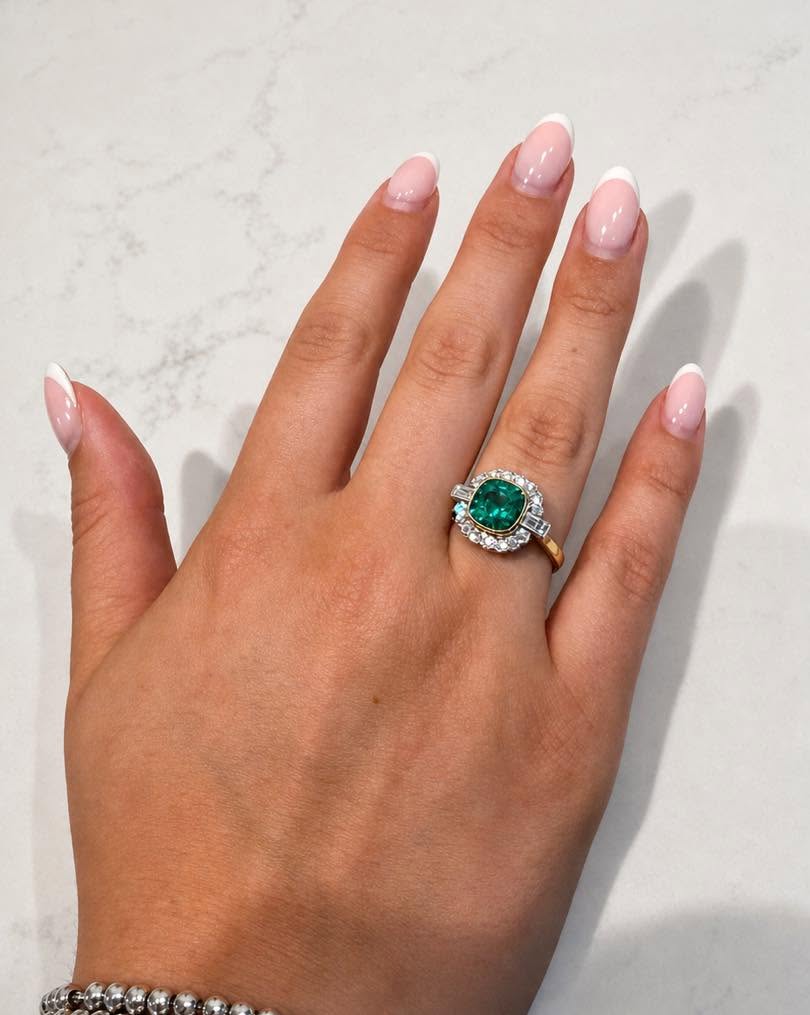 Emerald and diamond ring worn on hand